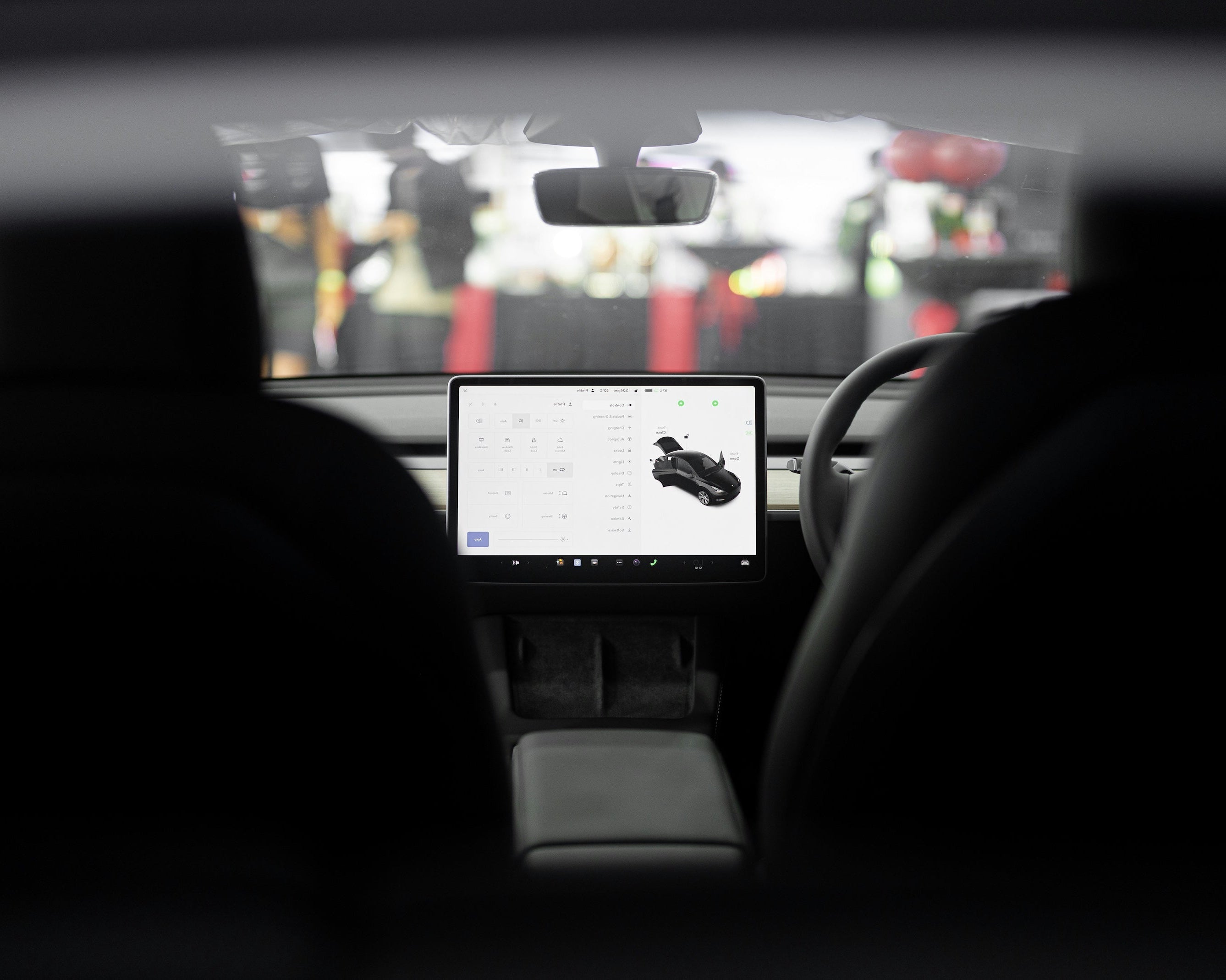 Person inside a car using a tablet displaying a product image.